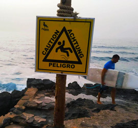 schodząc do muru plażowego ze znakiem ostrzegawczym